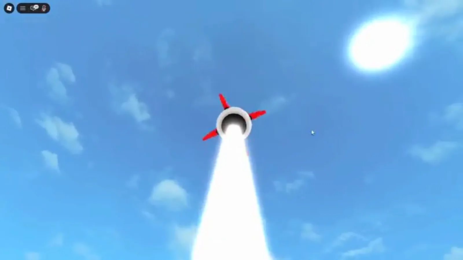 Um míssil de Merge a Nuke subindo por um céu limpo em direção ao sol instantes após o lançamento, com o rastro de exaustão aceso.